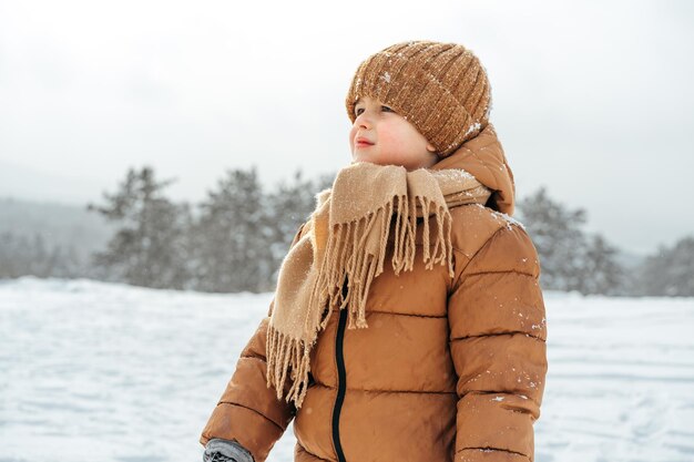 Ragazzino in un parco o in una foresta d'inverno