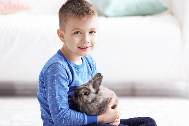 Foto ragazzino con adorabile coniglio in camera