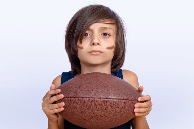 Маленький мальчик с американский футбольный мяч.