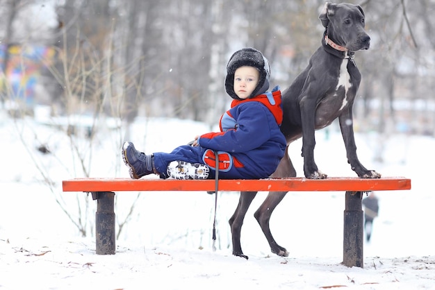 大きな黒い犬種を持つ小さな男の子