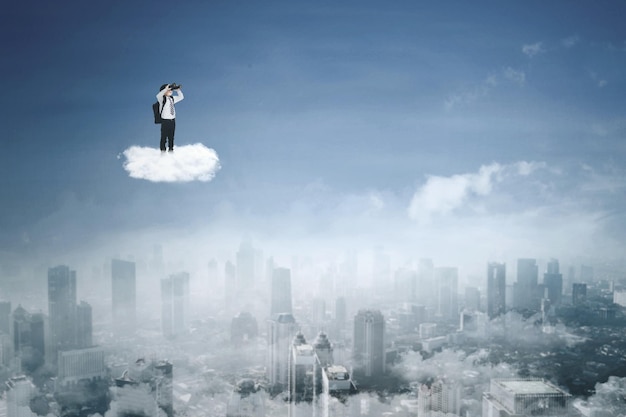 Little boy with binoculars on the cloud