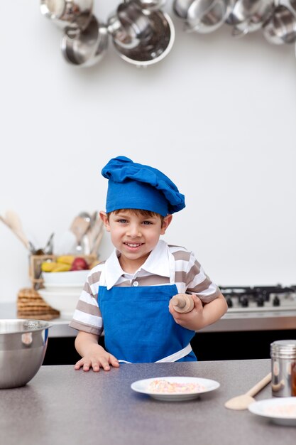 Photo little boy with blue hat and apron baking