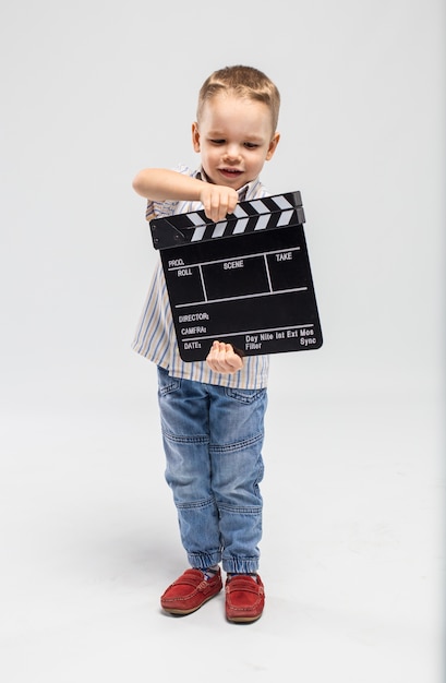 Photo little boy with clapper board at studio