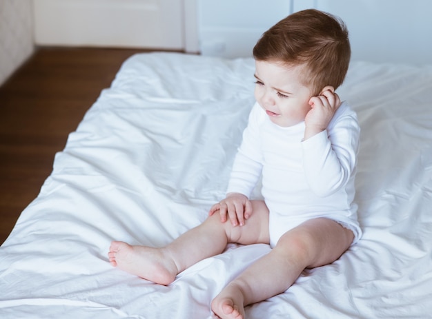 Little boy with ear pain moaning holding hand on ear at home, child headache pain, health care concept, ear protection , teeth pain side view