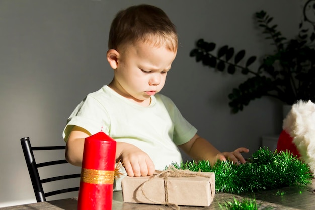 Маленький мальчик с подарками за новогодним столом