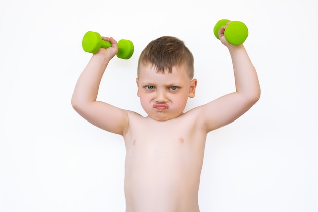 A little boy with green dumbbells on white isolated background