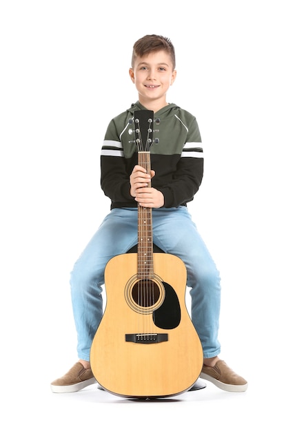 Photo little boy with guitar on white surface