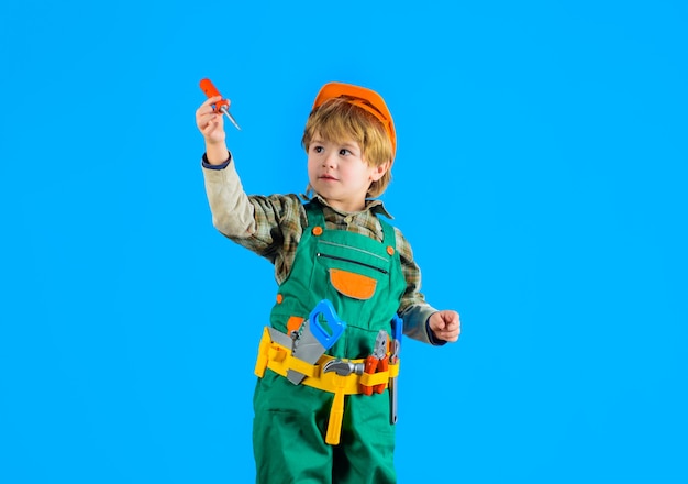 Ragazzino con casco e attrezzi da gioco per bambini costruttore di strumenti per costruire un ragazzino riparatore come