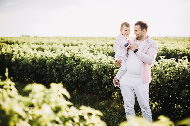 Little boy with his father on a green field