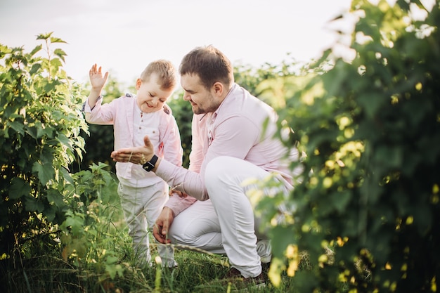 Little boy with his father on a green field