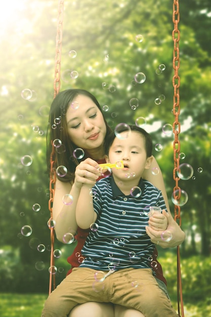 Little boy with his mother on the swing