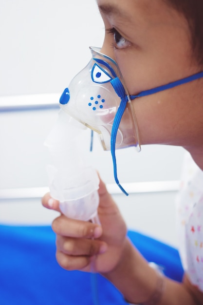 Little boy with inhalator mask in hospital