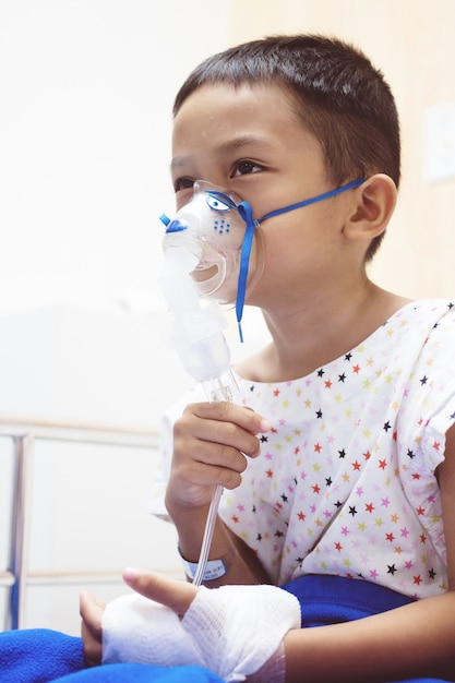 Little boy with inhalator mask in hospital