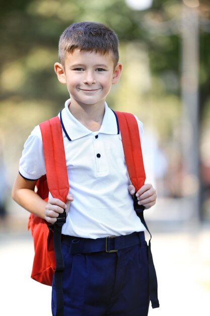 Foto ragazzino con grande borsa da scuola all'aperto