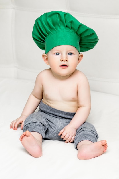 Little boy with metal ladle and cook hat