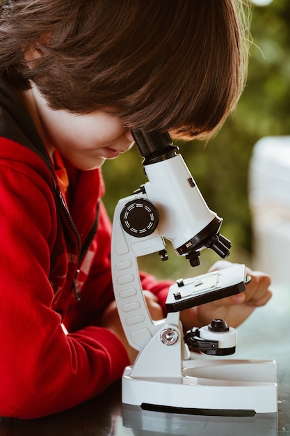 Photo little boy with microscope