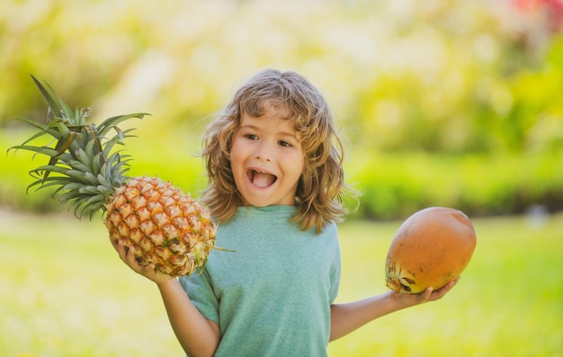Little boy with pineapple and coconut kid with summer fruit