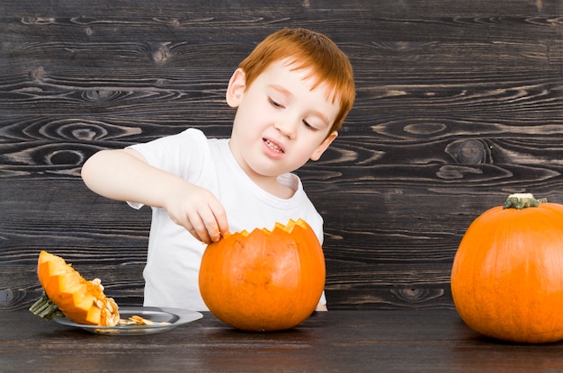 赤い髪の小さな男の子がハロウィーンの準備をします