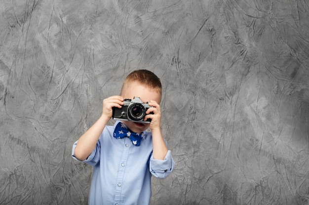 Ragazzino con una fotocamera a pellicola retrò