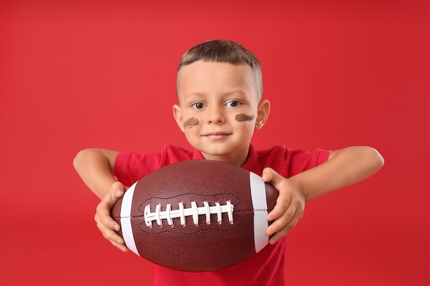 Photo little boy with rugby ball on color space