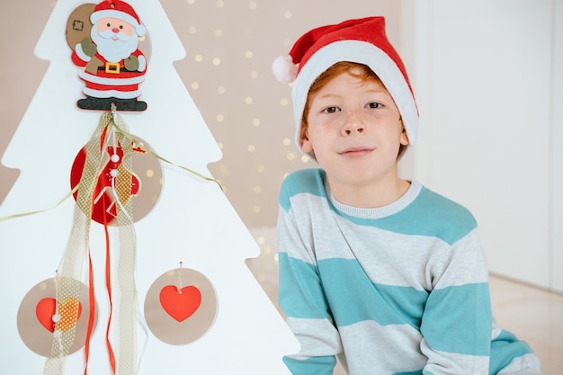 Little boy with Santa Claus next decorated tree