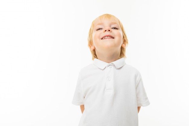 Little boy with short red hair, blue eyes, cute appearance, in white jacket, light blue pants, stands smiles