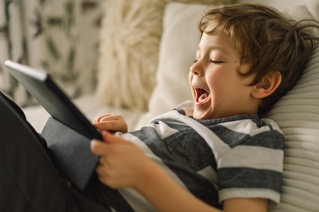 部屋にタブレットを持った少年。