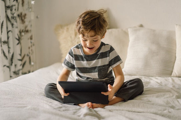 部屋にタブレットを持った少年