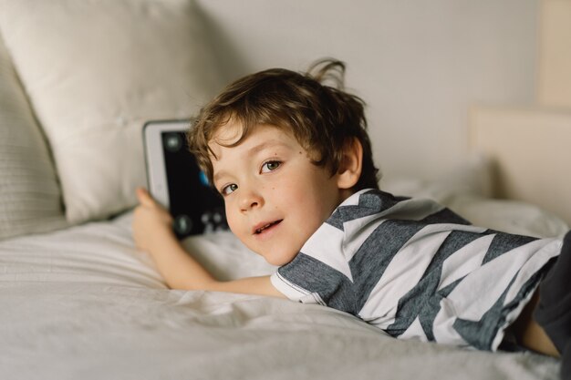 部屋にタブレットを持った少年