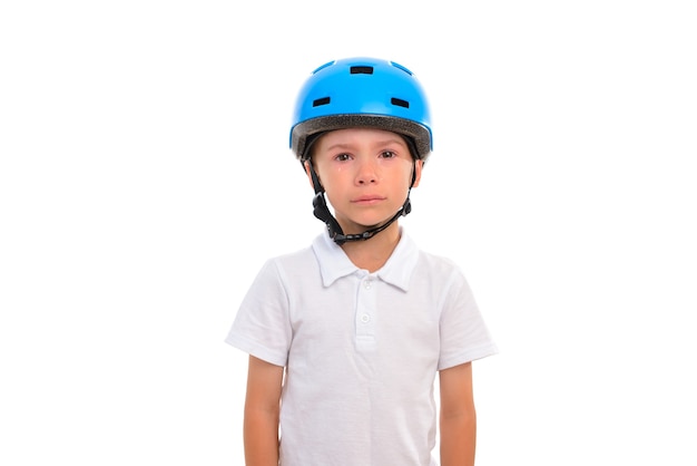 A little boy with tears in his eyes very upset and distressed stands  a blue bicycle helmet