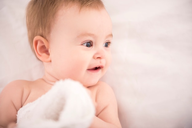 Little boy with a towel looks sideways.