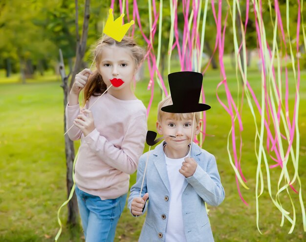 Little boy and woman posing with paper masks on a birthday