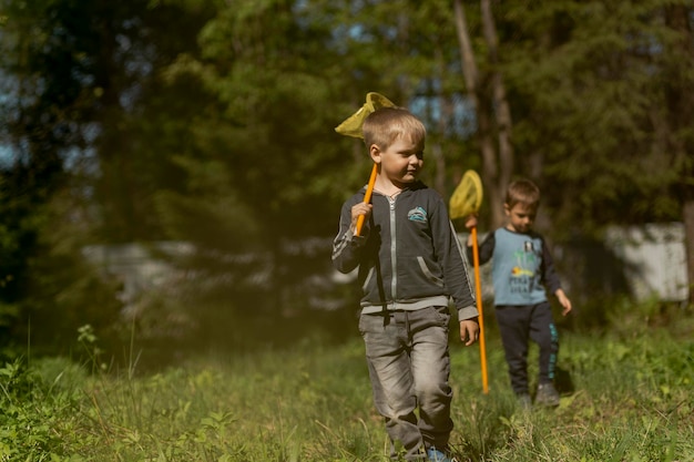 Photo little boys with butterfly nets in countryside image with selective focus