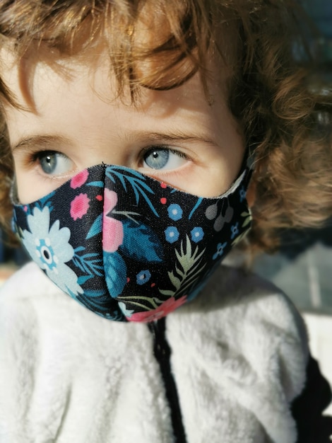 Little Brazilian girl using mask outdoors.