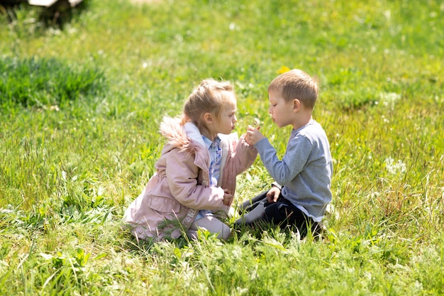 Little brother and sister playing together outside