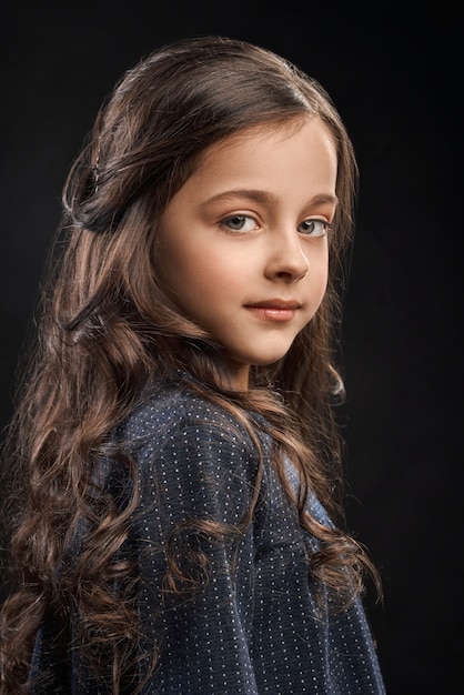 Little brunette posing on black isolated