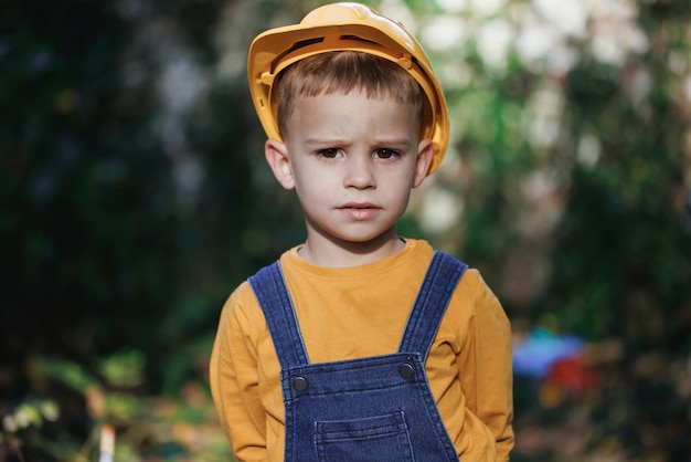 ヘルメットをかぶった小さなビルダー 子供が職人に扮した ビルダーの肖像画 ヘルメットをかぶった小さなビルダー