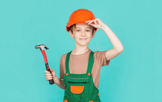 Little builder in helmet and hummer. Child dressed as a workman builder.