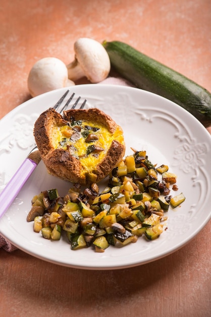 Foto piccola torta con il fuoco selettivo delle zucchine e dei funghi delle uova