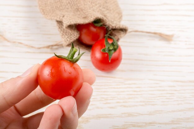 작은 캔버스 봉투와 은 익은 맛있는 신선한 체리 토마토