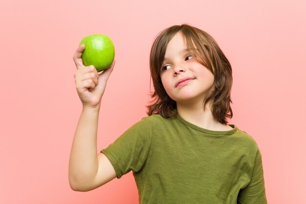 Little caucasian boy holding an apple