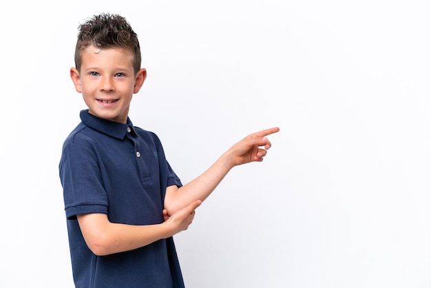 Little caucasian boy isolated on white background pointing finger to the side