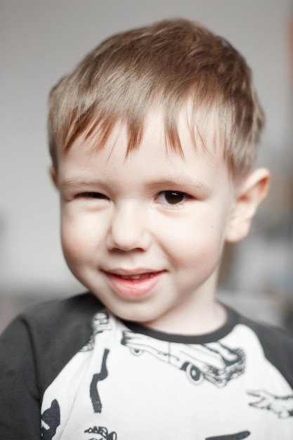 Little Caucasian boy smiling and looking at camera, lifestyle photography at home