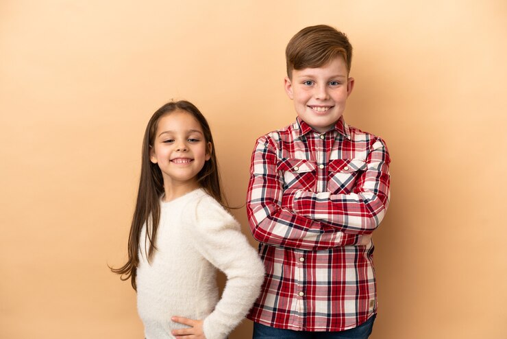Photo little caucasian brothers isolated on beige background