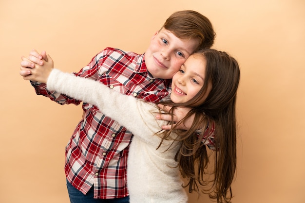 Piccoli fratelli caucasici isolati su fondo beige