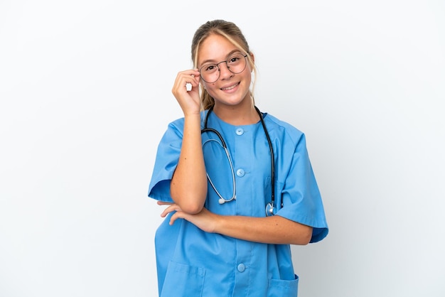 Little caucasian girl disguised as surgeon isolated on white background with glasses and happy