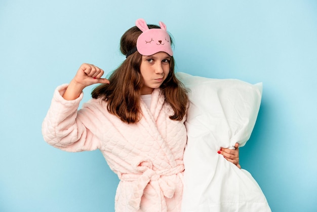 Little caucasian girl going to sleep isolated on blue background feels proud and self confident, example to follow.