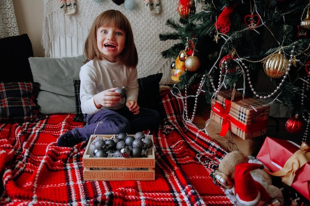 Little Caucasian Girl having fun with pet decorations and present Gifts concept New year concept