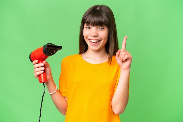 素晴らしいアイデアを指している孤立した背景にヘアドライヤーを保持している白人少女