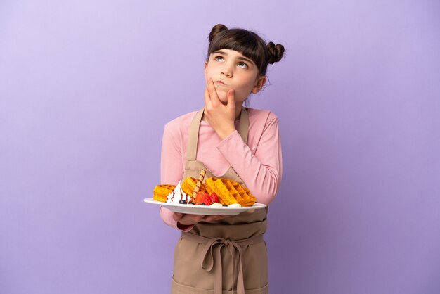 孤立したワッフルを保持している小さな白人の女の子